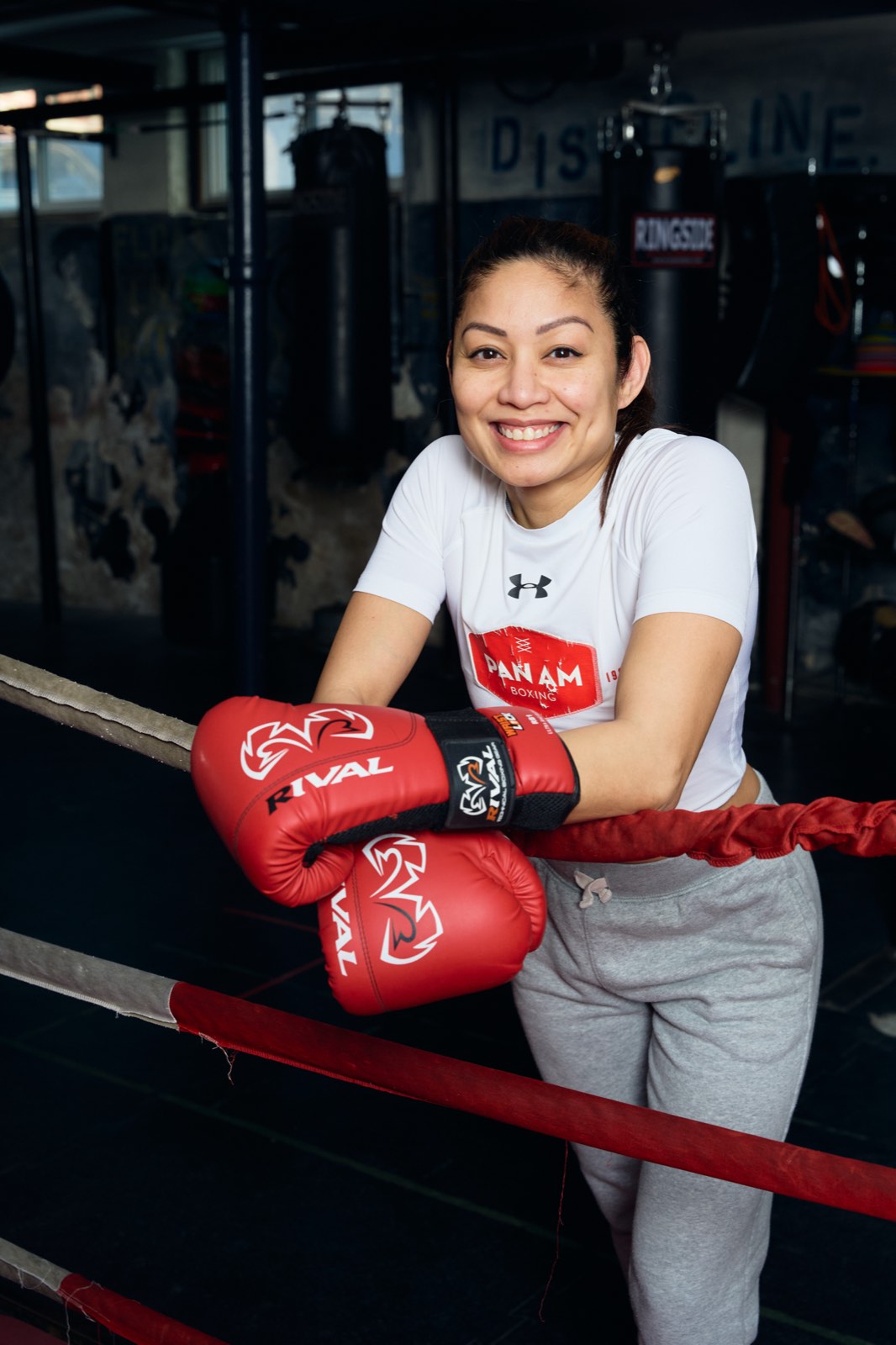 Woman smiling in Pan Am shirt with boxing gloves